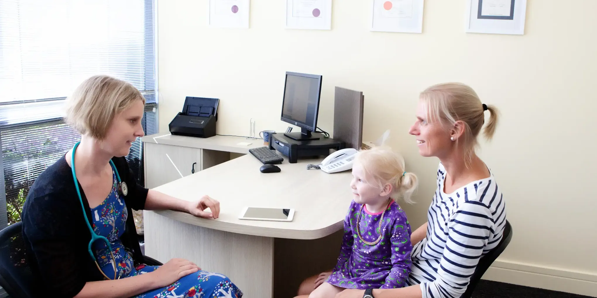 Dr. Wickham consulting with a patient and her toddler